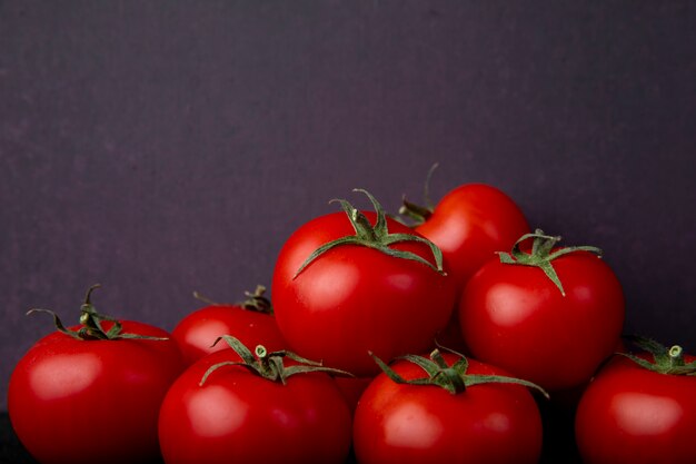 Pomodori interi sulla superficie viola