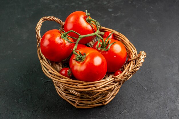 Pomodori rossi freschi di vista frontale all'interno del canestro