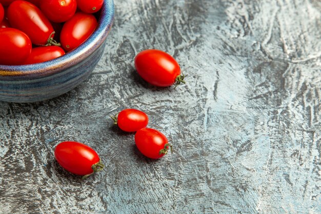 Pomodori rossi freschi di vista frontale all'interno della zolla sui precedenti scuro-chiari