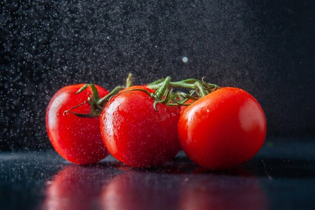 Pomodori rossi freschi di vista frontale su oscurità