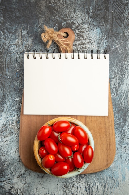 Pomodori rossi freschi di vista superiore con il blocco note