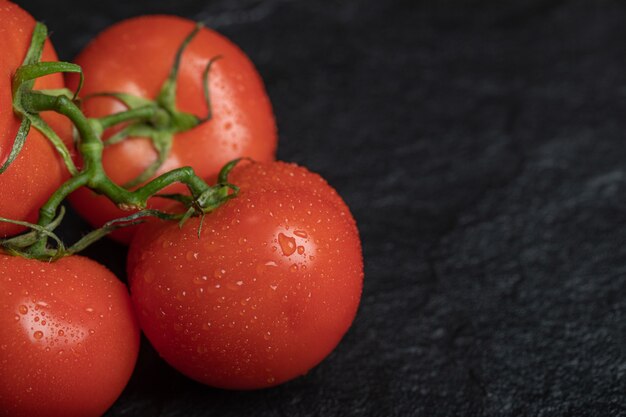 Pomodori rossi freschi su superficie scura