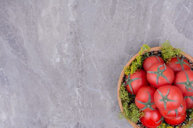 Pomodori rossi isolati in un piatto di legno