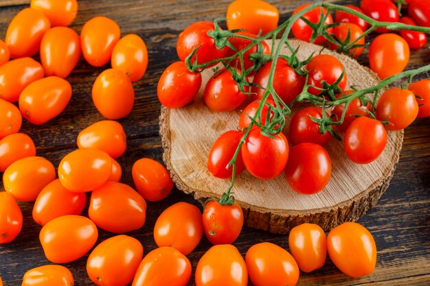 Pomodori sparsi sul tagliere di legno e. Veduta dall'alto.