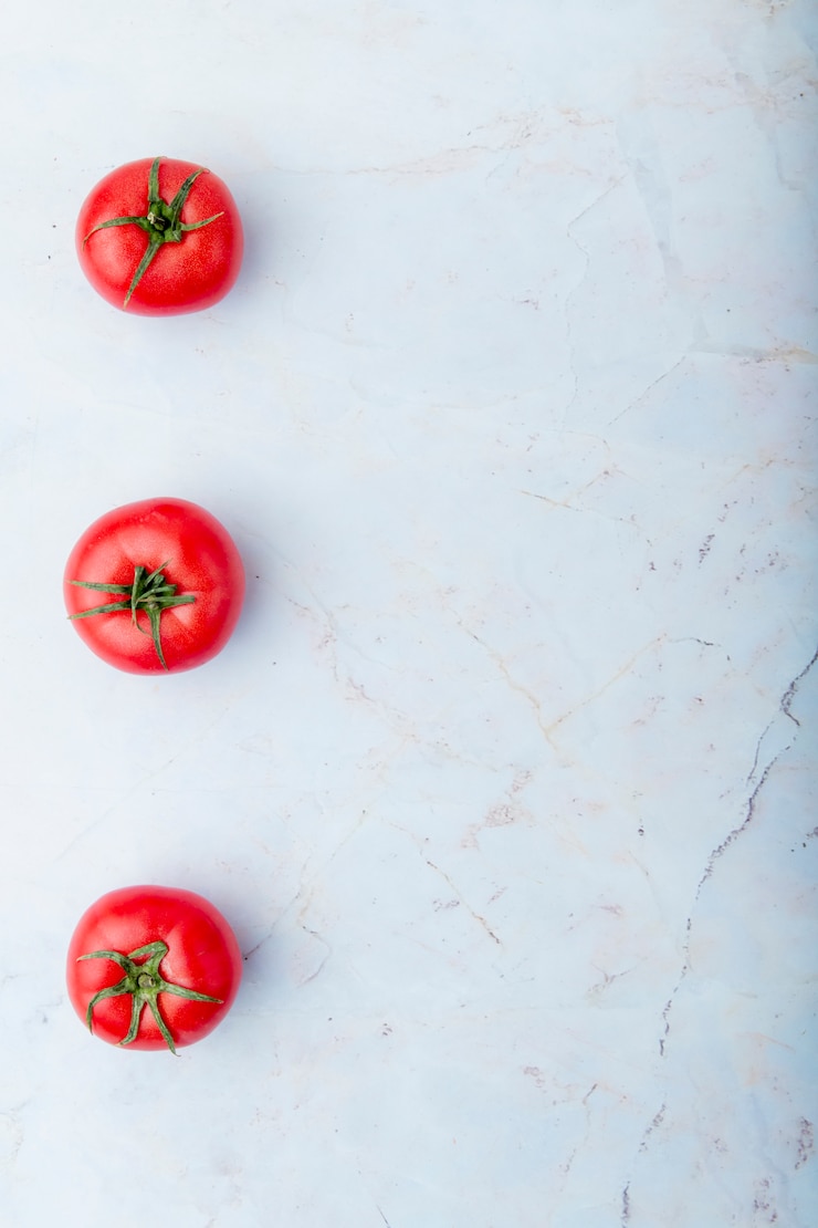 Foto gratuito pomodori sul lato sinistro sulla superficie bianca