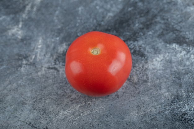Pomodoro biologico fresco su sfondo grigio. Foto di alta qualità