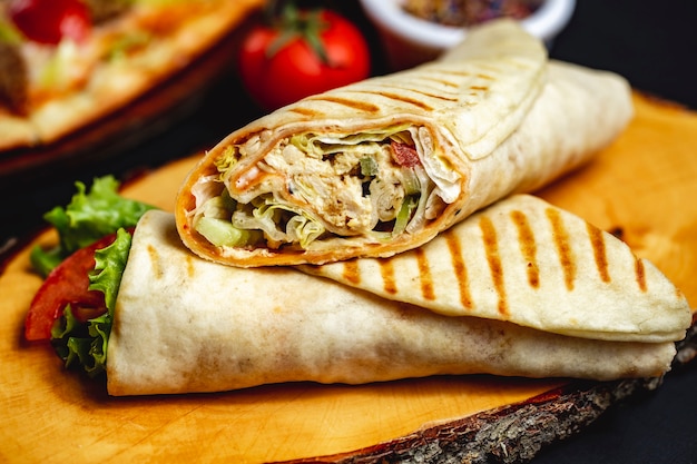 Pomodoro e maionese cetrioli della lattuga di pollo arrostiti rotolo del pollo di vista laterale in pita