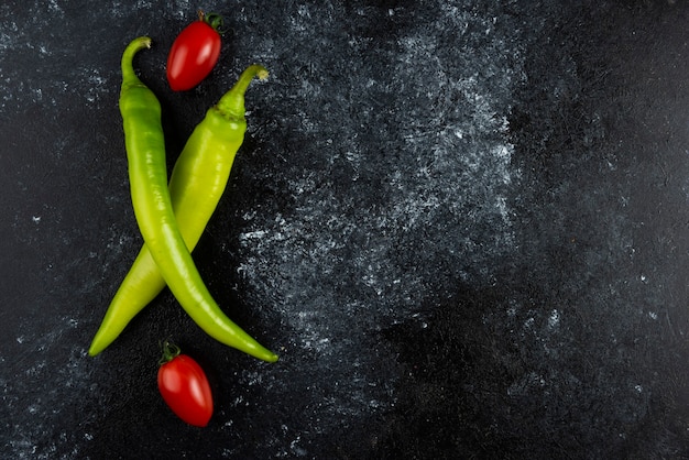 Pomodoro e peperoncino sulla superficie di marmo.