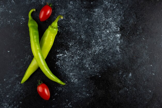 Pomodoro e peperoncino sulla superficie di marmo.