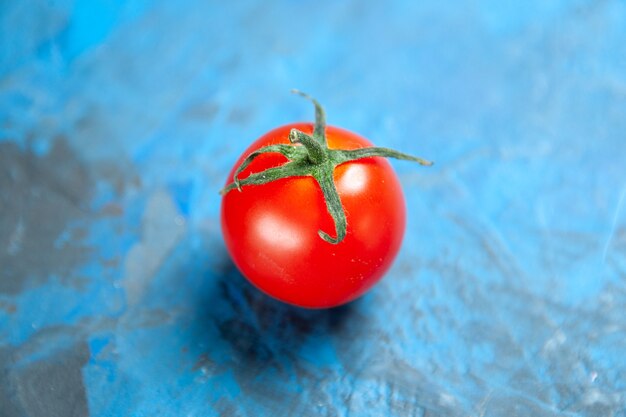 Pomodoro rosso fresco di vista frontale sulla tavola blu