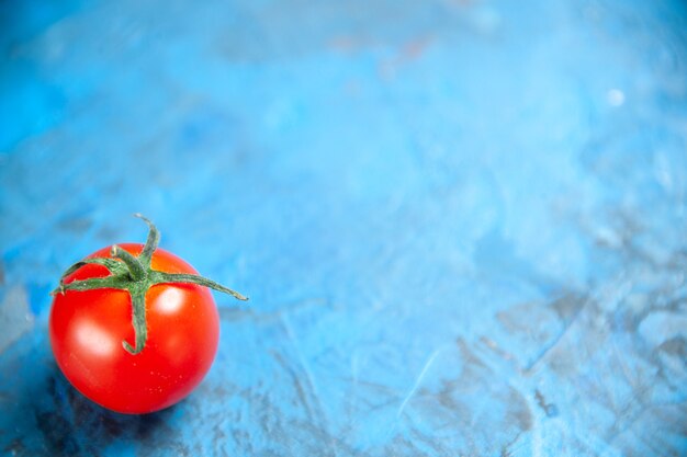 Pomodoro rosso fresco di vista frontale sulla tavola blu