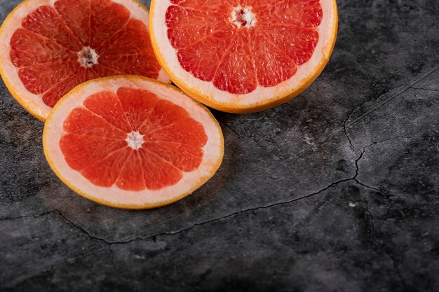 Pompelmo fresco succoso affettato su una tavola scura