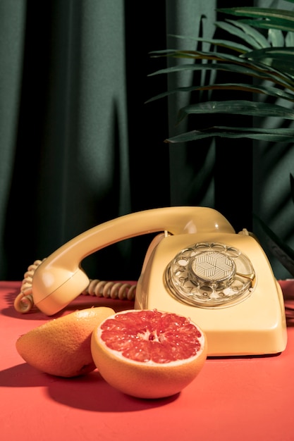 Pompelmo vista frontale accanto al telefono vintage