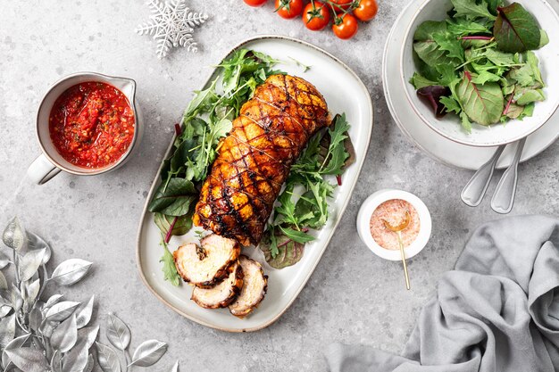 Porchetta un delizioso arrosto di maiale avvolto in un rotolo Piatto tradizionale italiano per le vacanze su sfondo grigio cemento