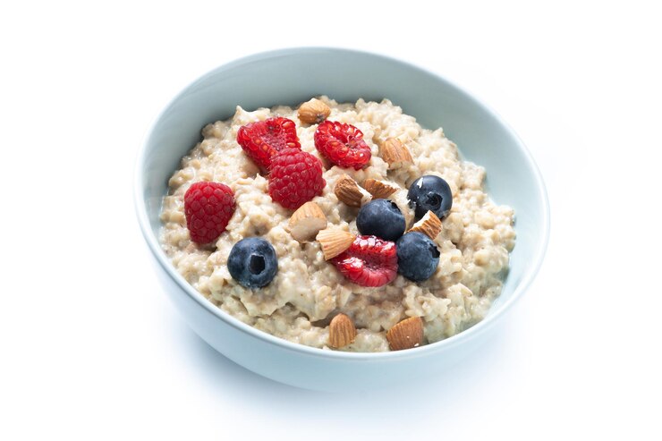 Foto gratuito porridge di farina d'avena con lamponi mirtilli e mandorle in ciotola isolata su sfondo bianco