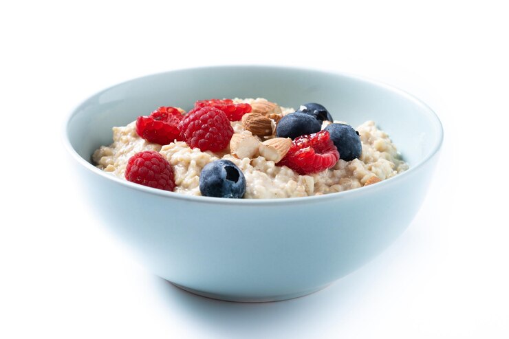 Foto gratuito porridge di farina d'avena con lamponi mirtilli e mandorle in ciotola isolata su sfondo bianco
