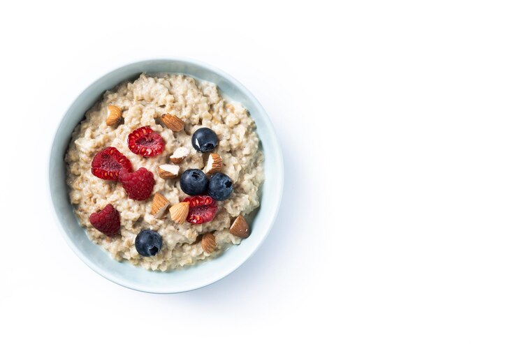 Foto gratuito porridge di farina d'avena con lamponi mirtilli e mandorle in ciotola isolata su sfondo bianco