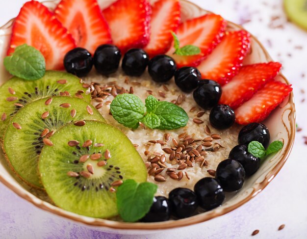 Porridge di farina d'avena gustoso e sano con frutta, bacche e semi di lino. Colazione salutare. Cibo fitness. Nutrizione appropriata.