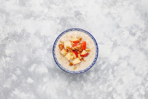 Porridge di farina d'avena in una ciotola con miele e fette di mela rossa, vista dall'alto