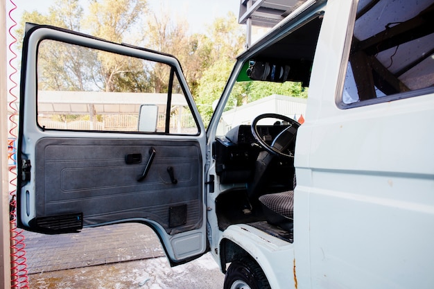 Porta aperta di un vecchio furgone bianco