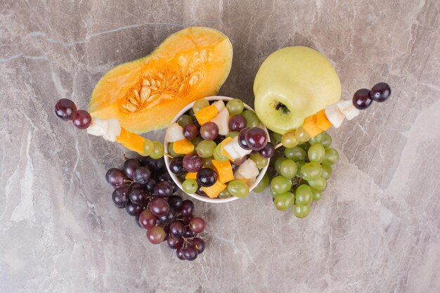 Portafrutta e frutta fresca sulla superficie di marmo.