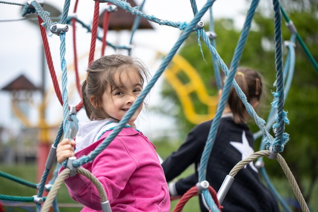 Portiere di una bambina sorridente che gioca nel parco giochi.