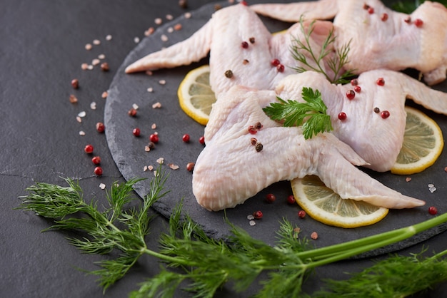 porzioni fresche di carne di pollo per cucinare e grigliare con condimento fresco. Coscia di pollo cruda cruda sul tagliere.