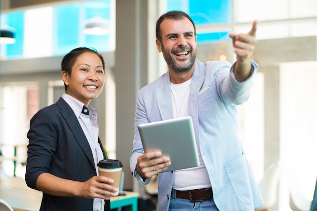 Positivi manager latino-americani con pausa caffè in ufficio