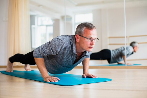 Posizioni di yoga di pratica dell'uomo adulto