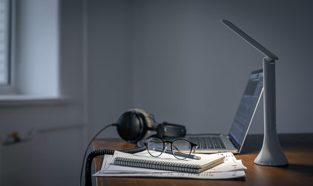 Posto di lavoro con cuffie e laptop nello spazio copia serale