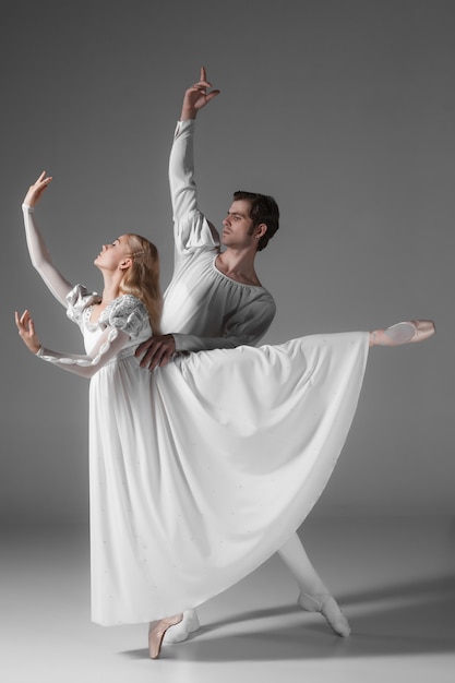 Pratica di due giovani ballerini di balletto. attraenti interpreti danzanti in bianco