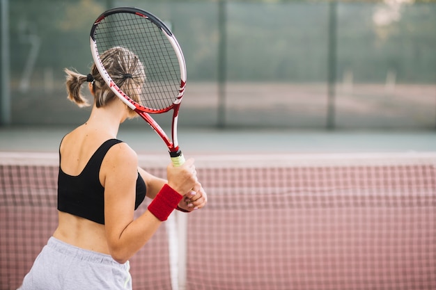 Pratica femminile del tennis di vista laterale