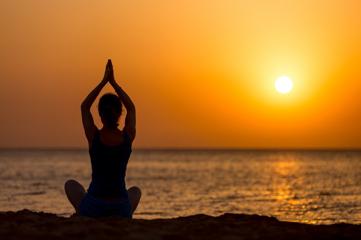 Foto gratuito pratica yoga sulla spiaggia
