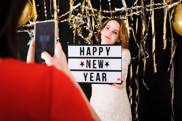 Prendendo la foto della ragazza che tiene il segno del buon anno