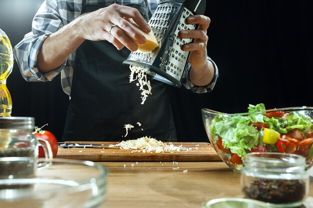 Preparare l'insalata. Cuoco unico femminile che taglia le verdure fresche. Processo di cottura. Messa a fuoco selettiva. Il cibo sano, cucina, insalata, dieta, concetto biologico di cucina