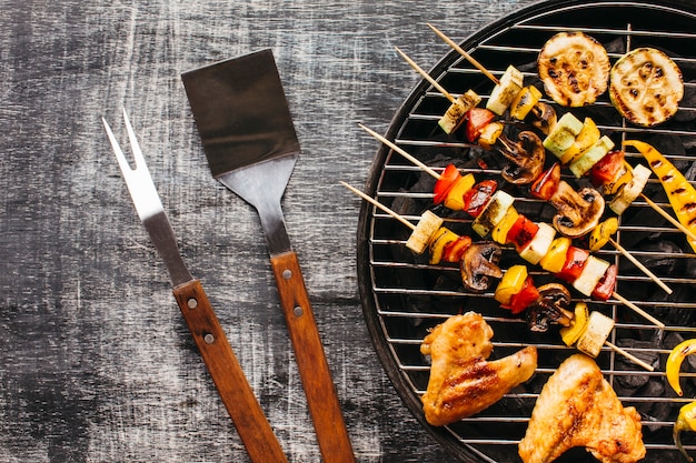 Preparazione della carne alla griglia sulla griglia del barbecue sopra fondo di legno