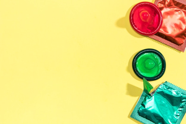 Preservativi colorati distesi piatti con copia-spazio