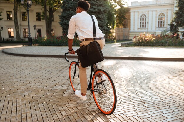 Primo mattino africano dell'uomo con la bicicletta che cammina all'aperto