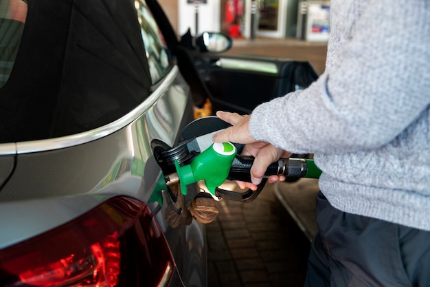 Primo piano a pompare a mano il gas in auto