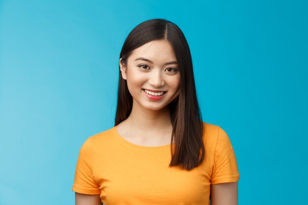 Primo piano affascinante attraente ragazza asiatica pura condizione della pelle pulita sorridente con gioia guardare fotocamera ottimista...
