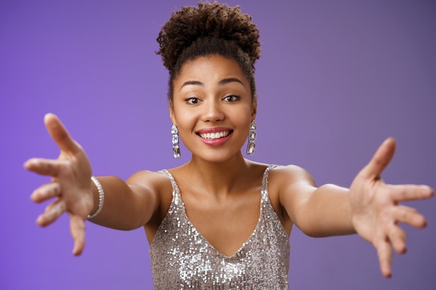 Primo piano affascinante toccato tenera ricca donna afroamericana in abito alla moda argento estendere il braccio...