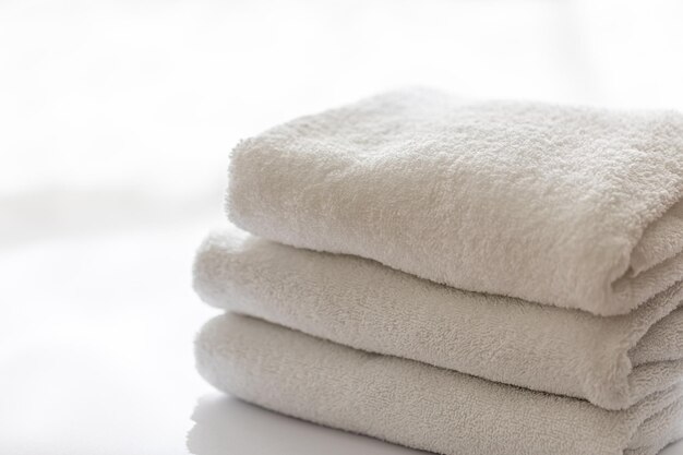 Primo piano asciugamani da bagno in spugna bianchi impilati concetto spa