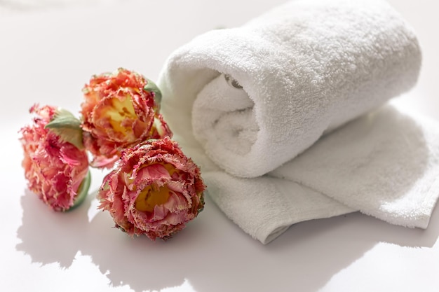 Primo piano asciugamano da bagno in spugna bianca e fiori