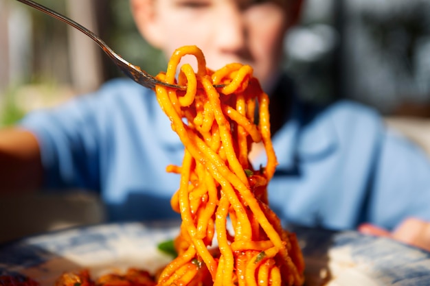 Primo piano bambino con deliziosi spaghetti