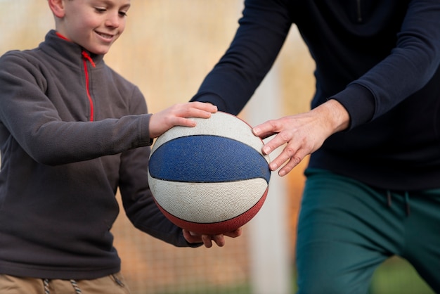 Primo piano bambino e adulto che giocano con la palla