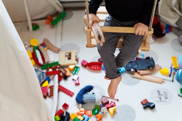 Primo piano bambino in altalena a casa