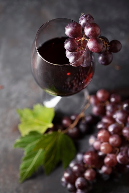 Primo piano bicchiere di vino circondato da uva