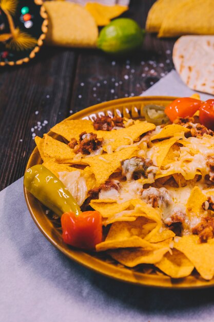 Primo piano dei nachos messicani gialli in piatto su carta da burro