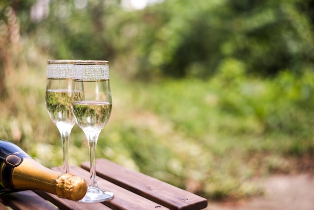 Primo piano dei vetri del champagne sulla tavola di legno all'aperto