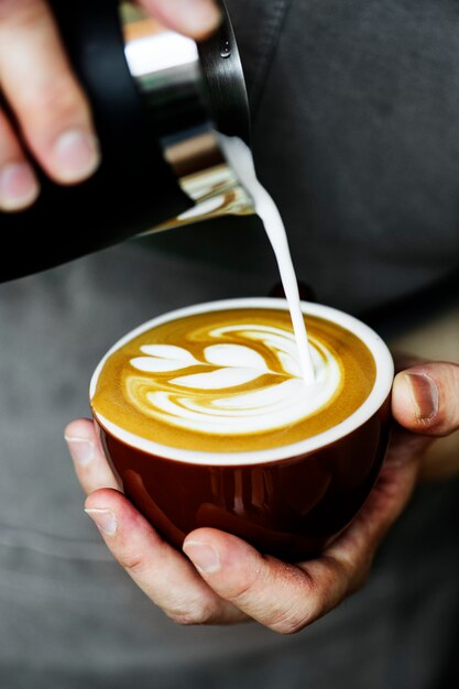 Primo piano del barista che fa arte del latte